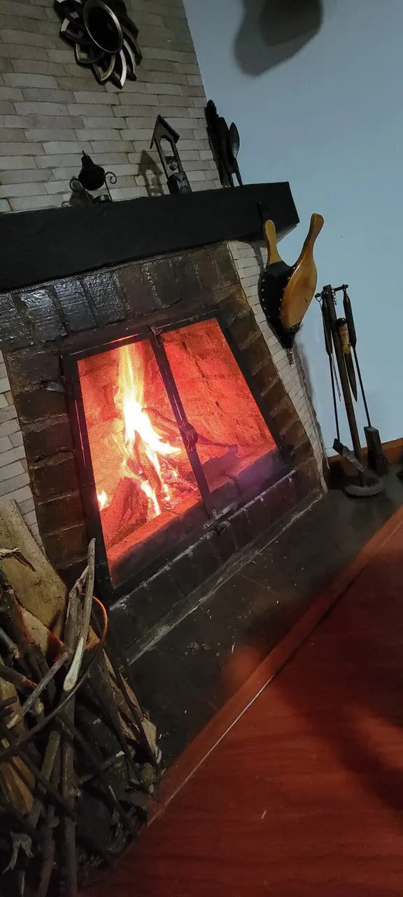 Chimenea rústica encendida en una casa campestre