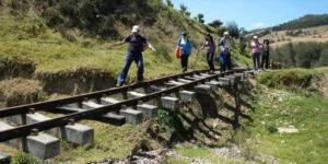Personas caminando por la carrilera del tren en medio de la naturaleza - caminatas ecológicas